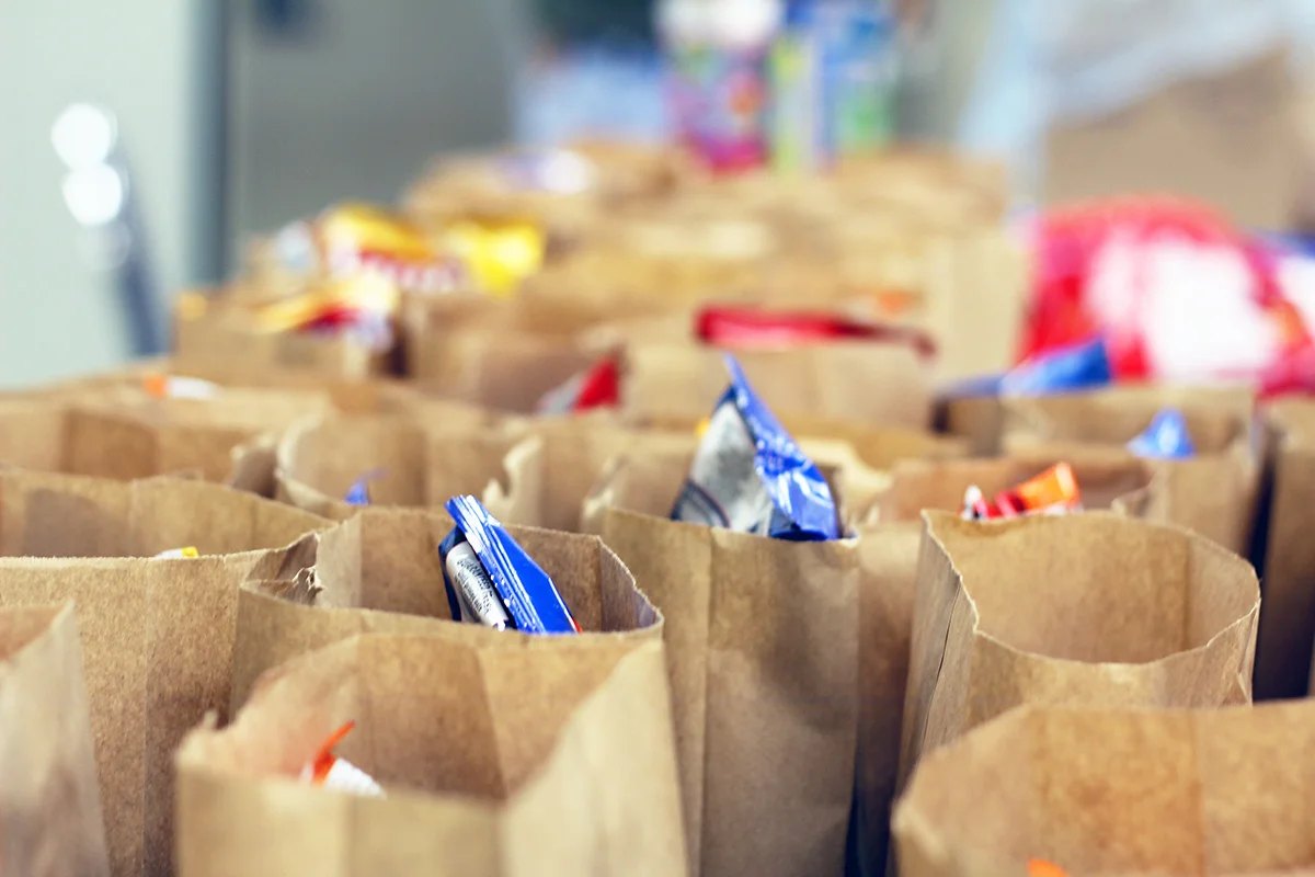 Rows of packed brown-bag lunches ready for delivery